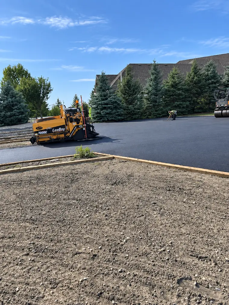 Crew raking fresh asphalt